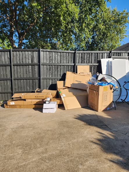 Pile of junk and boxes by fence before removal